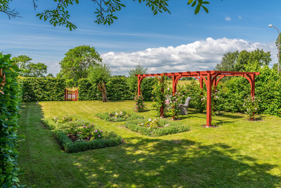 Röd pergola  med svängda detaljer