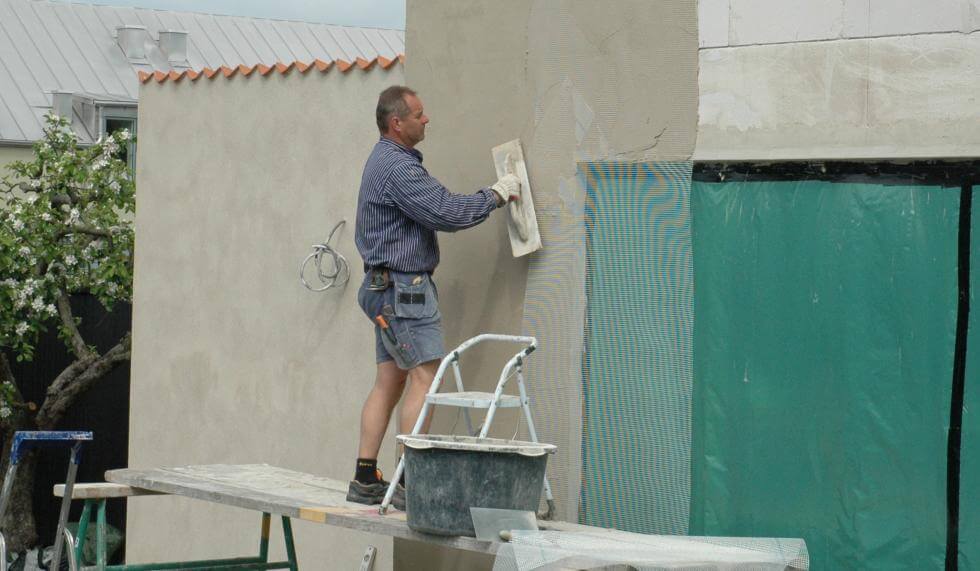 Muraren Dennis putsar nybyggt stenhus av lättbetong.