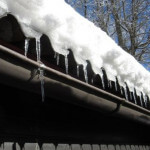 Snö på ett tak med svart hängränna